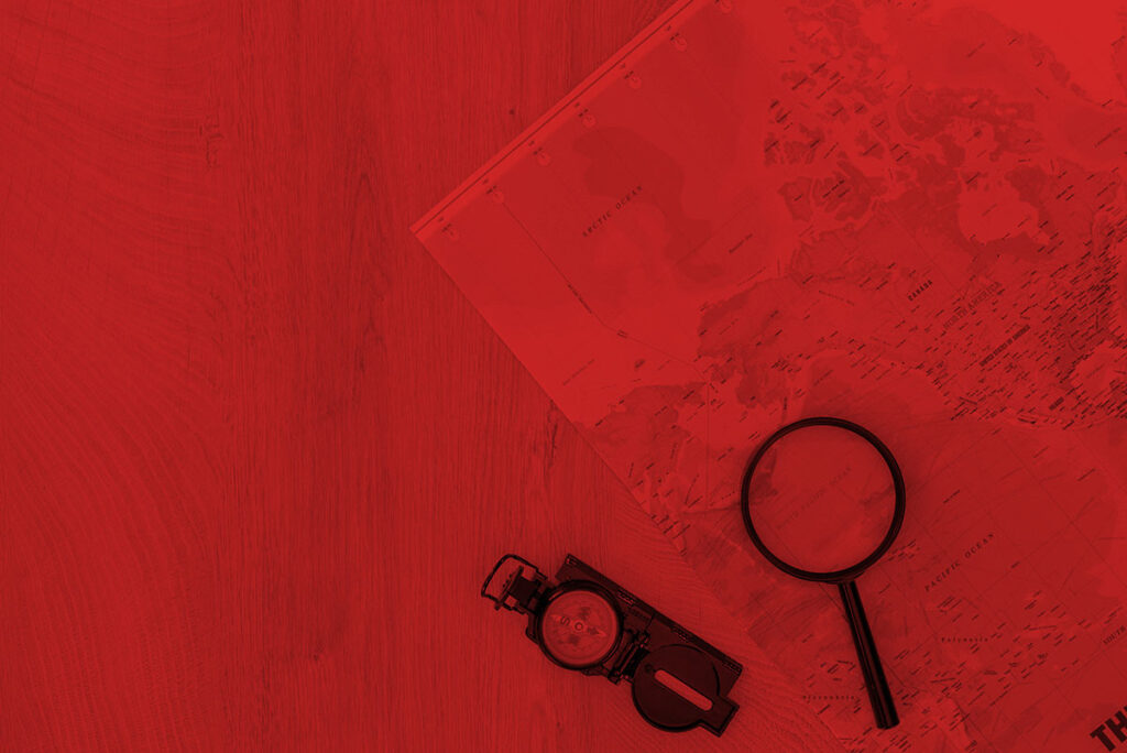 A compass and magnifying glass laying on top of a map on top of a map for the header image.