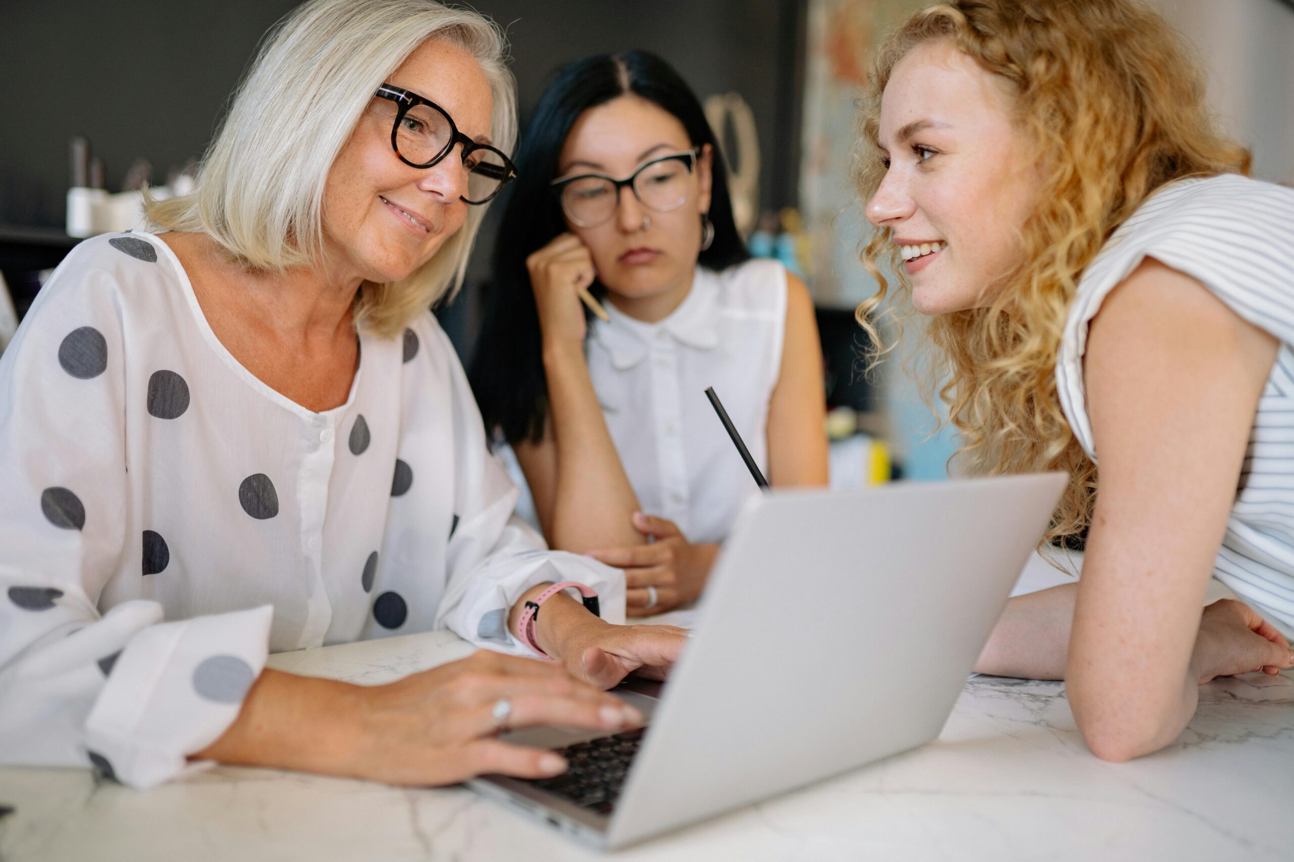 Image of women talking in front a laptop for the blog The Six Metamorphoses of Business Transition: Why It's More Than Just a Handoff
