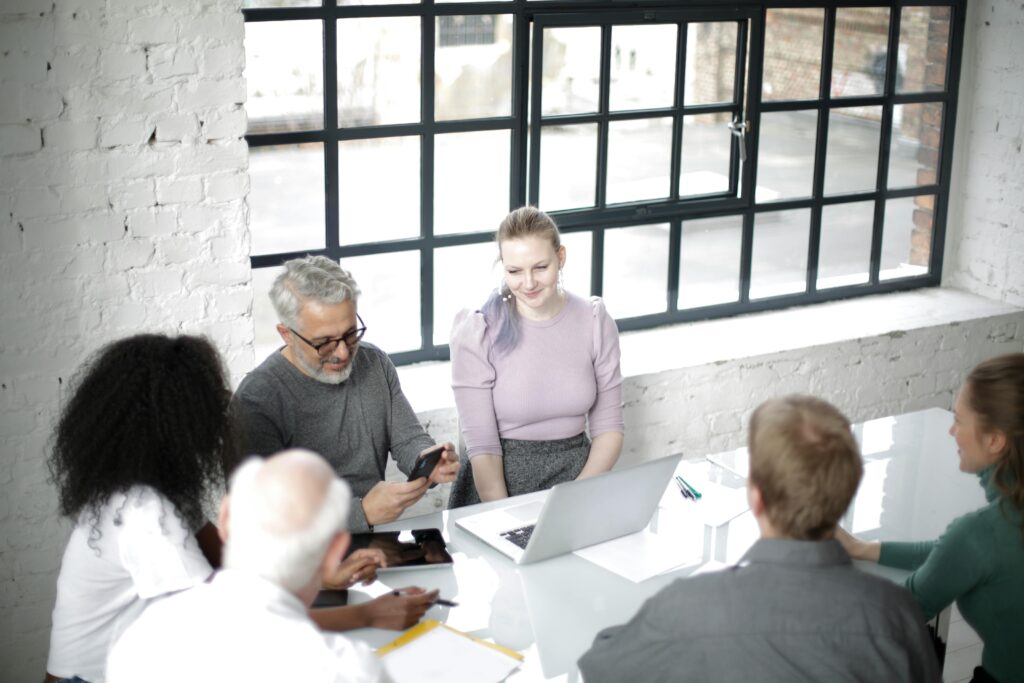 Image of people in front of a conference table for the blog Stewarding the Seat: How Family Governance Evolves Across Generations