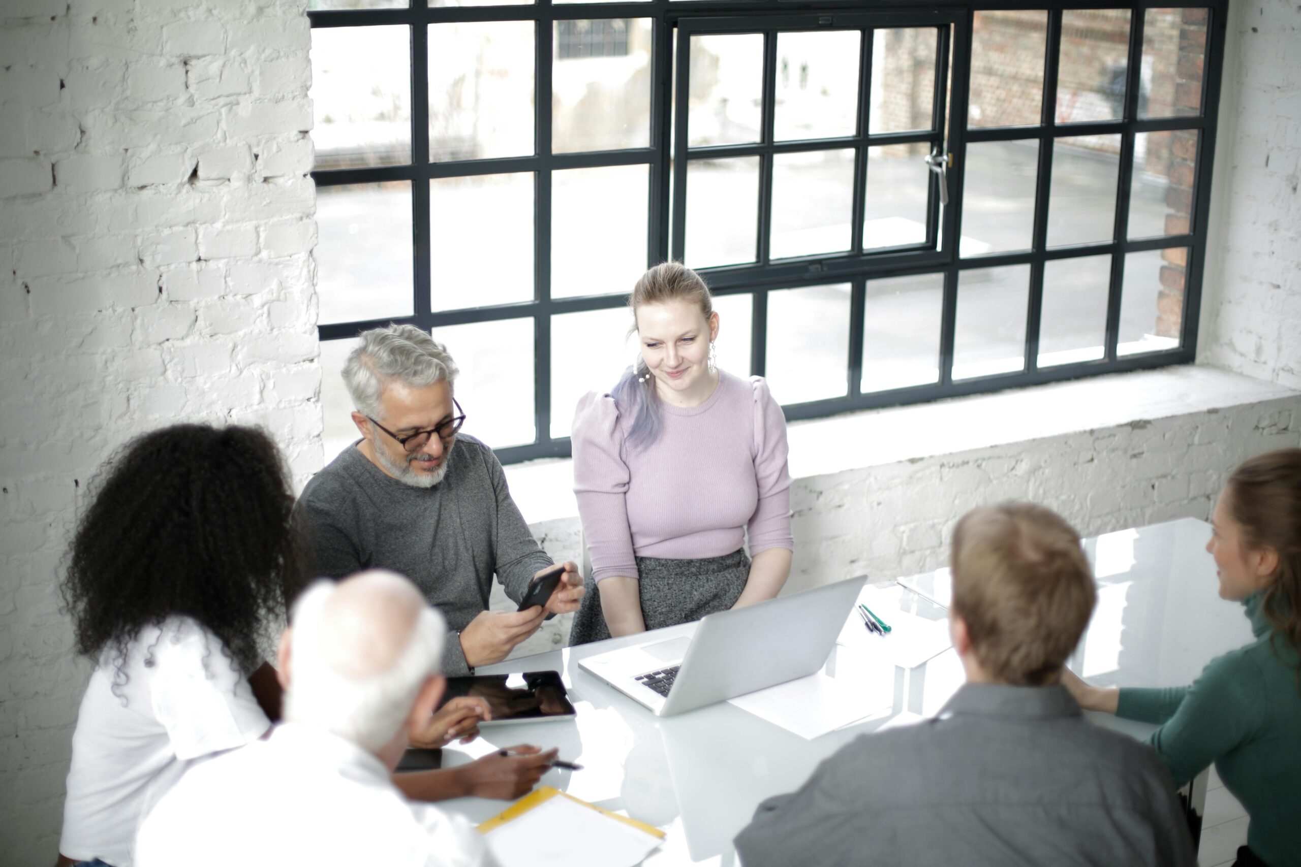 Image of people in front of a conference table for the blog Stewarding the Seat: How Family Governance Evolves Across Generations