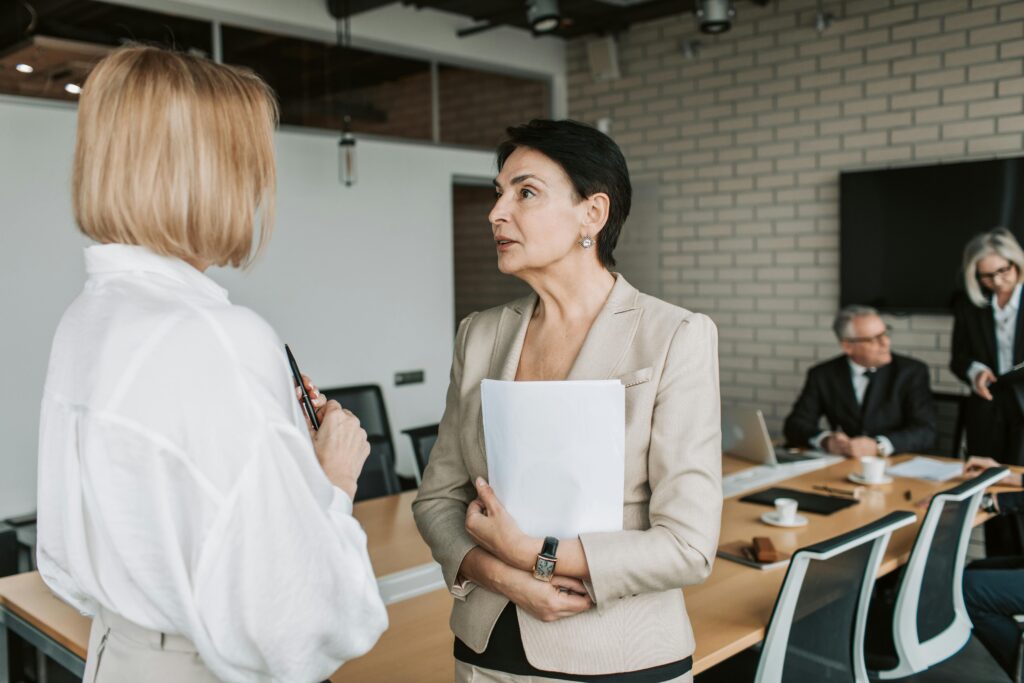 Image of two women talking in a meeting room for the blog, How to Talk to Your Adult Children About Wealth: A Guide for Parents Who Feel Stuck