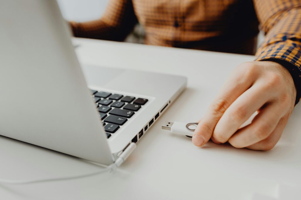 Image of a hand inserting a flash disk into a laptop for the blog, The Question That Could Derail Your Transition: Who Actually Owns Your Digital Assets?