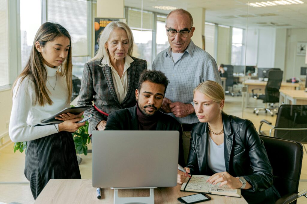 Image of people looking at a computer screen for the blog, How to Transition a Family Business to the Next Generation