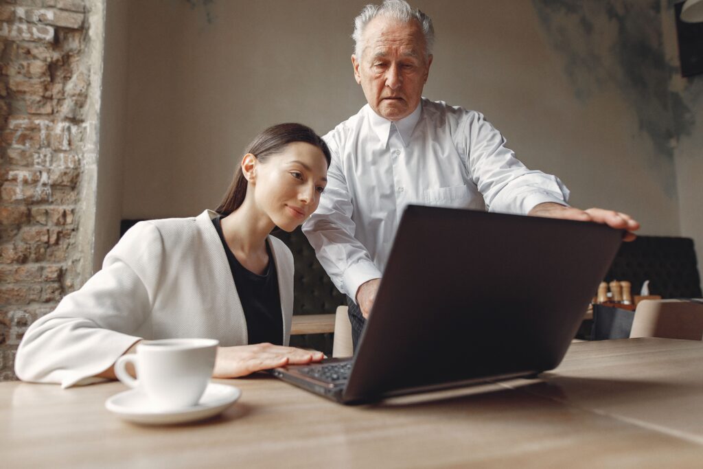 Image of an old man and a woman looking at a laptop for the blog, When the Only Choices Are Hard Ones, Look for the Gray