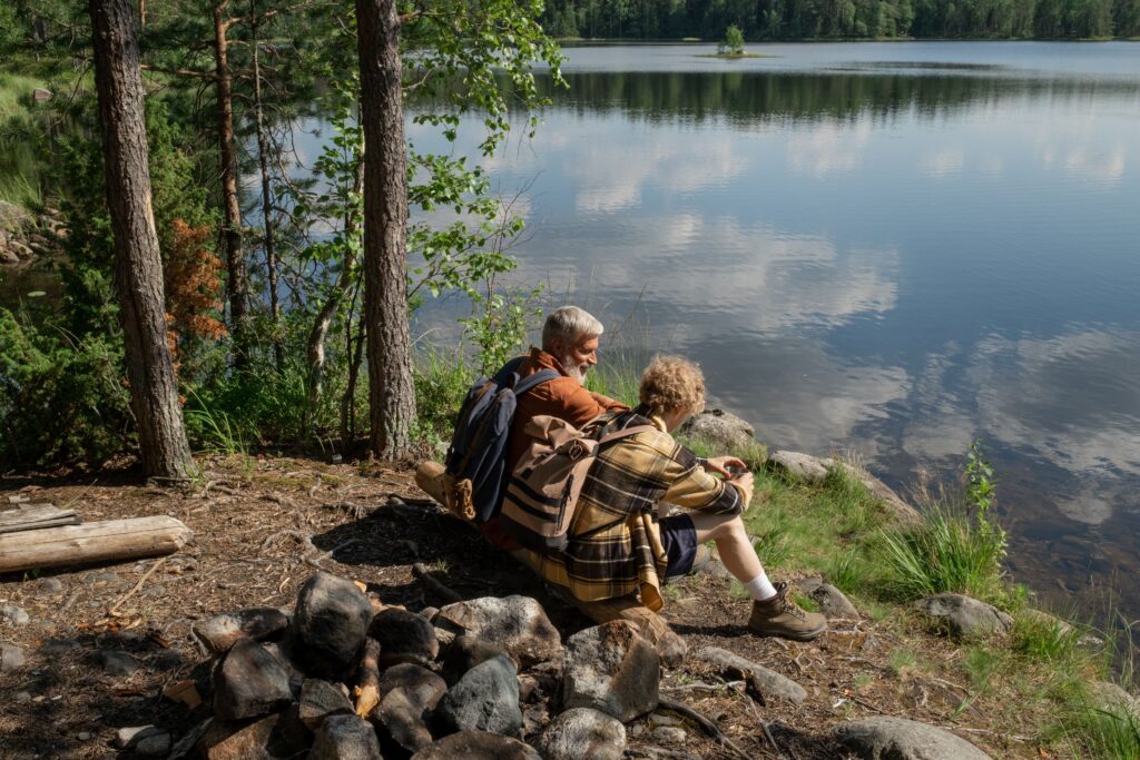 Image of an old man and woman sitting by a body of water for the blog, Business Transition Strategy for Founders Looking for “What’s Next”